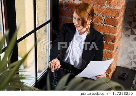 Attorney studying legal papers against brick background Attorney studying legal papers against brick background 137258230