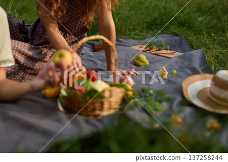 Close view of hands passing apple on soft blanket surface 137258244