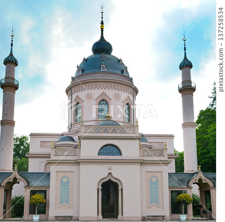 Majestic pink mosque with tall minarets under a cloudy sky. 137258534