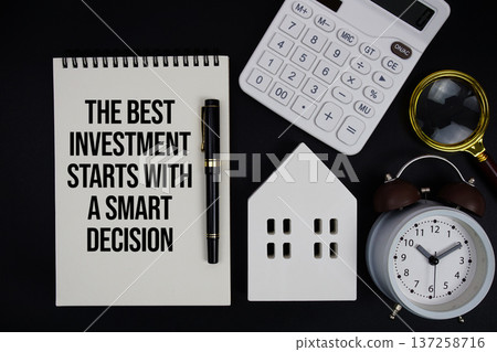 Notepad with the phrase "The Best Investment Starts With A Smart Decision" surrounded by a pen, calculator, magnifying glass, clock, and house model Notepad with the phrase "The Best Investment Starts With A Smart Decision" surrounded by a pen, calculator, magnifying glass, clock, and house model 137258716
