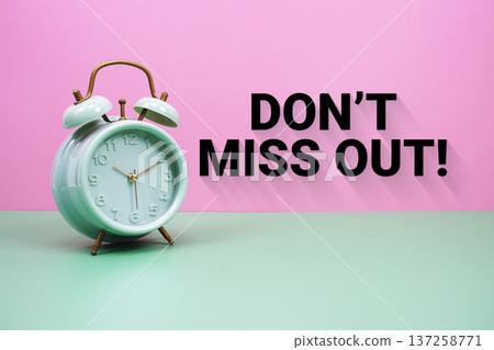 Black alarm clock on a pastel green and pink background with the text "Don't miss out" Black alarm clock on a pastel green and pink background with the text "Don't miss out" 137258771