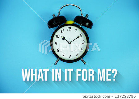 What's In It For Me? text and alarm clock on blue background 137258790