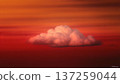 A single, puffy cloud floats serenely against a vibrant, fiery orange and red sunset sky. Dreamy and peaceful. 137259044