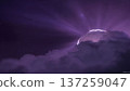 Dramatic purple light rays shine through a storm cloud, creating a stunning and ethereal atmospheric phenomenon. 137259047