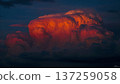 Dramatic cumulonimbus cloud formation illuminated by the setting sun, creating a fiery and awe-inspiring skyscape. 137259058