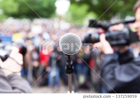 Microphone in focus at street protest, blurred cameraman and photographer in background Microphone in focus at street protest, blurred cameraman and photographer in background 137259059