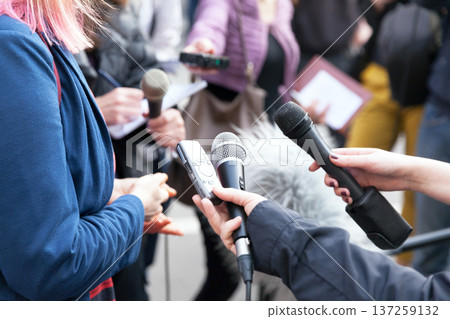 Public figure talking to the media, journalists holding microphones at press conference Public figure talking to the media, journalists holding microphones at press conference 137259132