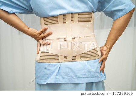 Asian senior pain back wearing elastic support belt with walker. Asian senior pain back wearing elastic support belt with walker. 137259169