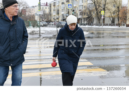Friends share hot drinks from thermos while standing on snowy wooden deck Friends share hot drinks from thermos while standing on snowy wooden deck 137260034