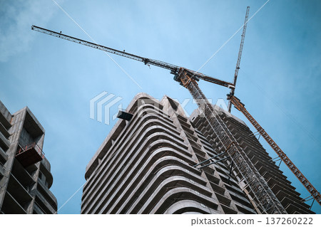 Tall multi-storey modern buildings are being built against the background of the blue sky. High quality photo Tall multi-storey modern buildings are being built against the background of the blue sky. High quality photo 137260222