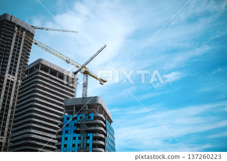 Tall multi-storey modern buildings are being built against the background of the blue sky. High quality photo Tall multi-storey modern buildings are being built against the background of the blue sky. High quality photo 137260223