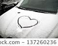 Heart on the hood of a snow-covered car. High quality photo 137260236