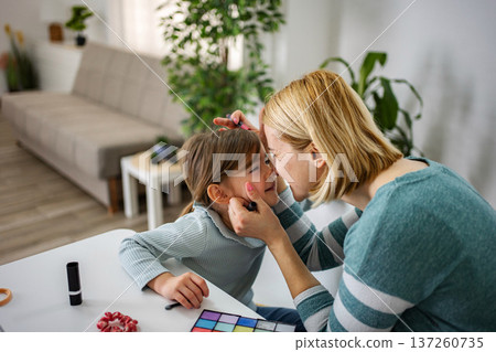 Mother and daughter bonding doing creative makeup together Mother and daughter bonding doing creative makeup together 137260735