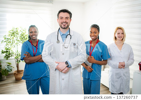 Diverse medical team smiling in hospital hallway Diverse medical team smiling in hospital hallway 137260737