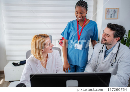 Medical professionals collaborating on computer in clinic office Medical professionals collaborating on computer in clinic office 137260764