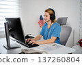 Nurse teleconsulting with patient using computer and headset 137260804