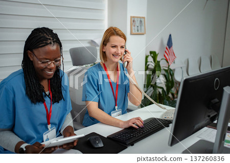 Healthcare professionals working at reception desk Healthcare professionals working at reception desk 137260836