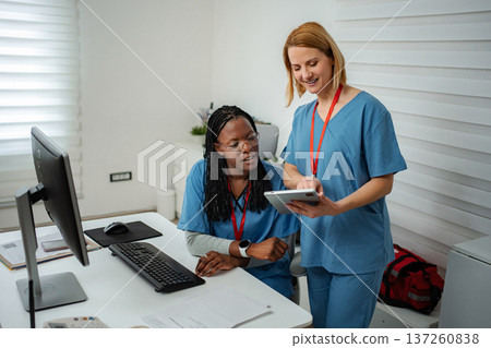 Nurses collaborating on digital tablet in modern medical office 137260838