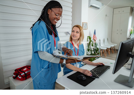 Healthcare professionals collaborating on medical records in hospital 137260914