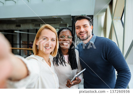 Diverse business team taking selfie in modern office 137260936