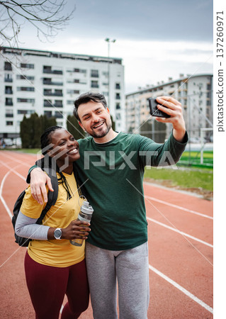 Diverse couple taking selfie after morning fitness workout Diverse couple taking selfie after morning fitness workout 137260971