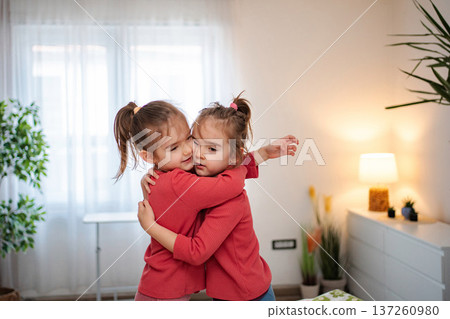 Cute twin sisters embracing expressing love and bonding Cute twin sisters embracing expressing love and bonding 137260980