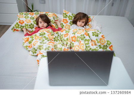Preschool age children watching laptop in bed 137260984