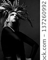 Woman wearing feathers looking up black and white portrait 137260992