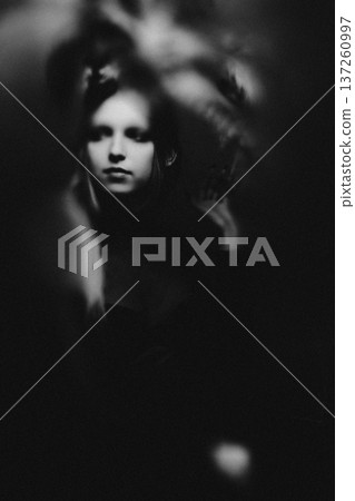 Young woman face emerging from dark mysterious blur 137260997