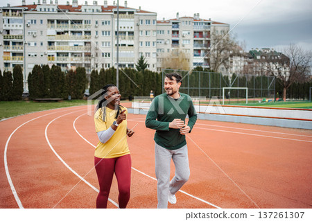 Diverse friends running together exercising on track Diverse friends running together exercising on track 137261307