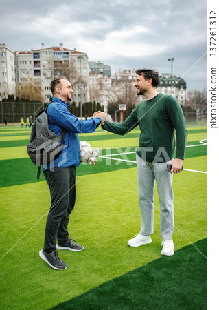 Male friends shaking hands before playing soccer Male friends shaking hands before playing soccer 137261312