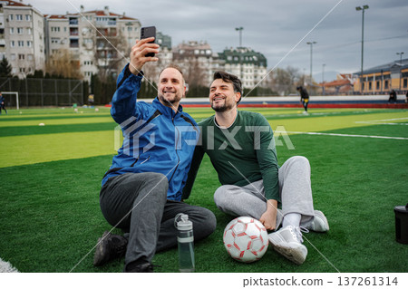 Friends taking selfie on soccer field after training 137261314