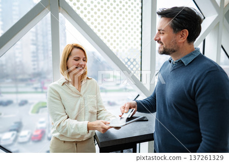 Man paying with credit card using digital tablet in modern office Man paying with credit card using digital tablet in modern office 137261329