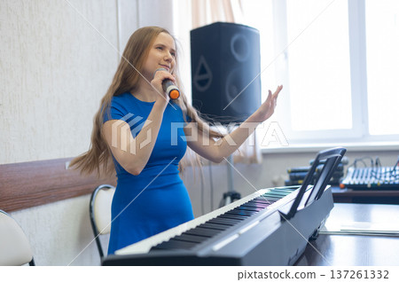 Caucasian woman singing into microphone. Caucasian woman singing into microphone. 137261332