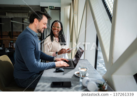 Coworkers collaborating remotely laughing while discussing business ideas 137261339