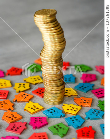 Rising Stack of Gold Coins Among Colorful Wooden Houses Real Estate Growth Concept 137261398