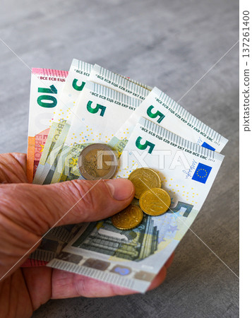 Hand Holding Euro Banknotes and Coins Close Up European Currency Finance Concept 137261400