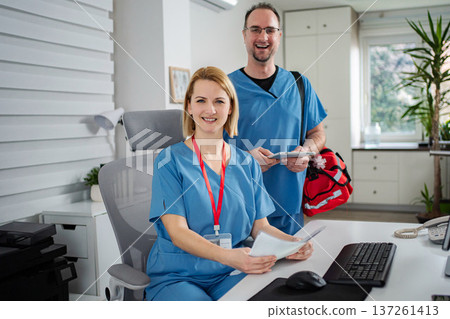 Healthcare professionals working in office smiling at camera Healthcare professionals working in office smiling at camera 137261413