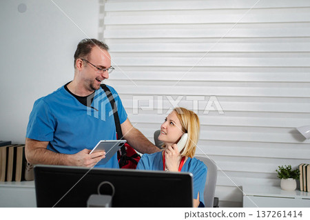 Healthcare workers communicating at clinic with tablet and phone 137261414
