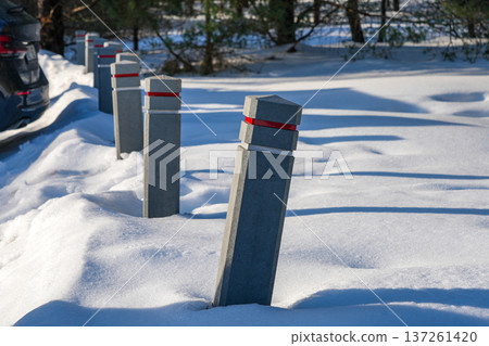 Mutually uneven Concrete Parking Bollards Covered in Snow During Winter 137261420