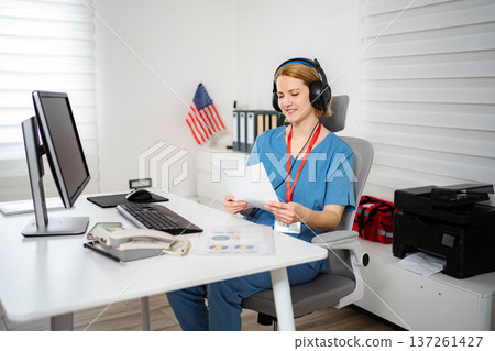Female healthcare worker reviewing documents in a telework office Female healthcare worker reviewing documents in a telework office 137261427