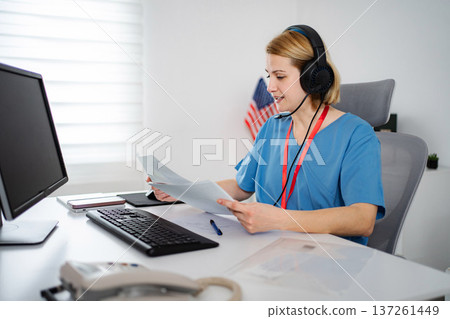 Healthcare professional working on computer during telehealth consultation 137261449