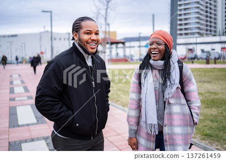 Young black couple smiling talking outdoors in city park 137261459