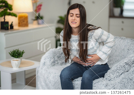 Woman experiencing sudden abdominal pain feeling stomach ache Woman experiencing sudden abdominal pain feeling stomach ache 137261475