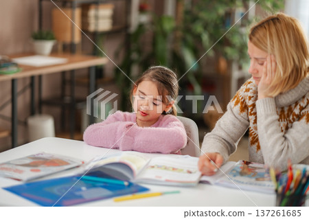 Tired mother and child struggling with homework at home Tired mother and child struggling with homework at home 137261685