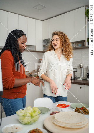 Diverse women cooking tacos together in home kitchen 137261731