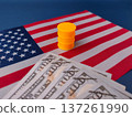 The image illustrates the relationship between the US dollar currency and the oil industry, featuring cash on a US flag with a miniature oil barrel. 137261990