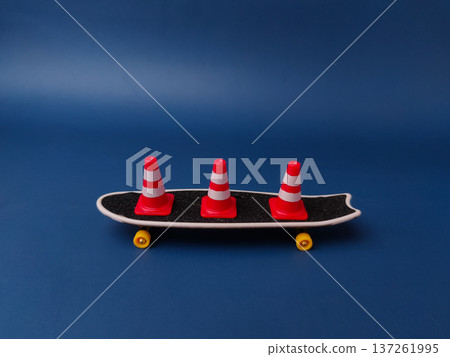 The item shown is a miniature finger skateboard with three small traffic cones. The item shown is a miniature finger skateboard with three small traffic cones. 137261995