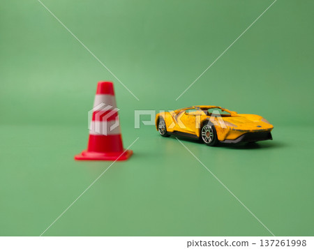 The image features miniature plastic traffic cones and a toy car used for educational traffic simulations or play. 137261998