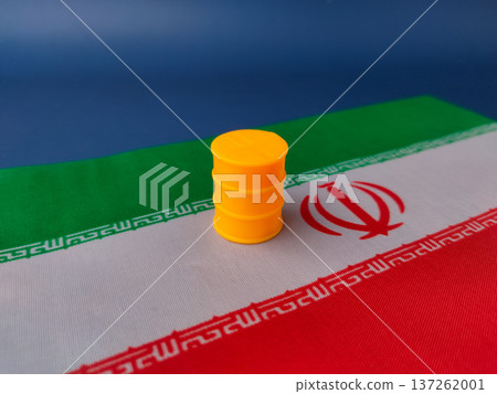 The image features a small yellow plastic barrel or oil drum placed on top of the flag of Iran. The image features a small yellow plastic barrel or oil drum placed on top of the flag of Iran. 137262001